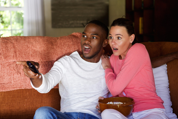 Asustada joven pareja viendo la televisión
 - Foto, imagen