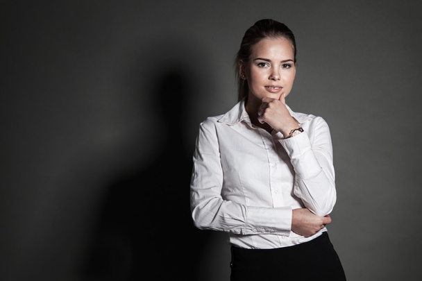 Portrait of young businesswoman on dark background - Photo, image