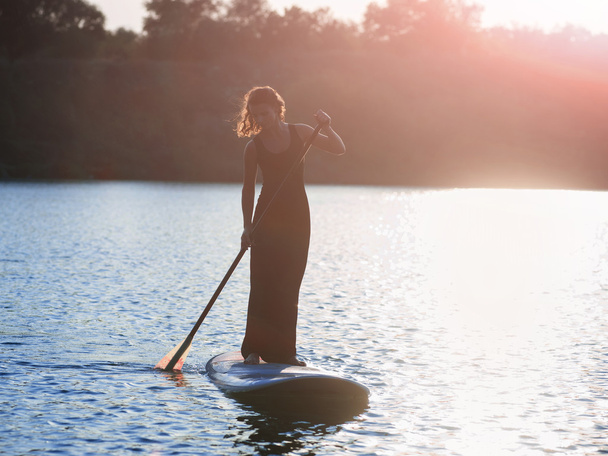 silhouette of a beautiful woman on stand up paddle board. SUP05 - Valokuva, kuva