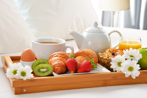 Bandeja de desayuno en la cama en la habitación del hotel
 - Foto, imagen