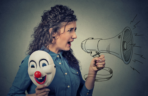 Woman with megaphone and clown mask screaming  - Фото, зображення
