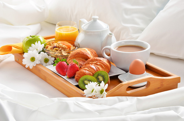 Aamiainen tarjotin sängyssä hotellihuoneessa
 - Valokuva, kuva