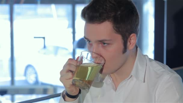 Primer plano del hombre bebe té en la cafetería
 - Metraje, vídeo
