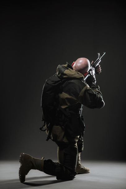 soldier man hold Machine gun on a  dark background - Zdjęcie, obraz