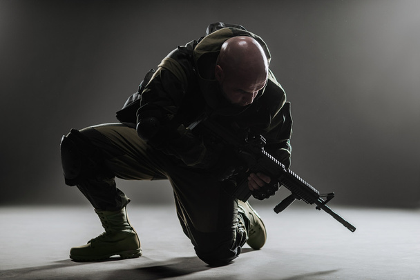 soldier man hold Machine gun on a  dark background - Fotoğraf, Görsel