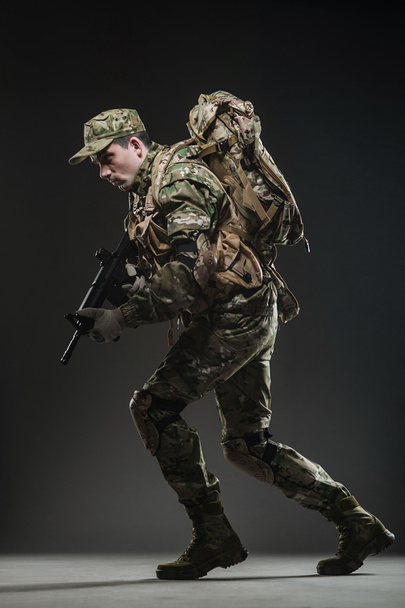 Soldier man hold Machine gun on a  dark background - Fotó, kép