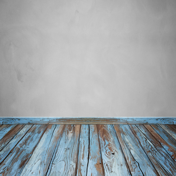 Интерьер комнаты с бетонной стеной и деревянным полом
 - Фото, изображение