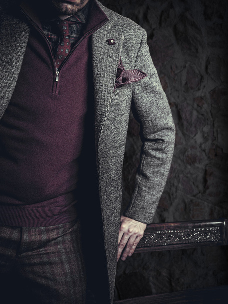 Мужчина-модель в повседневной одежде позирует на сером фоне
 - Фото, изображение