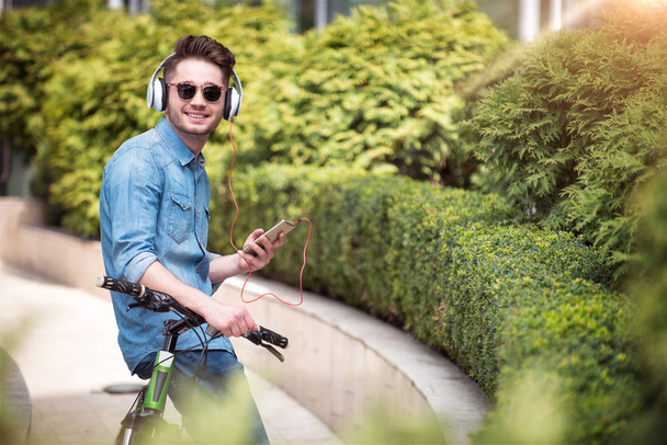 Positive guy holding a bicycle - Fotó, kép
