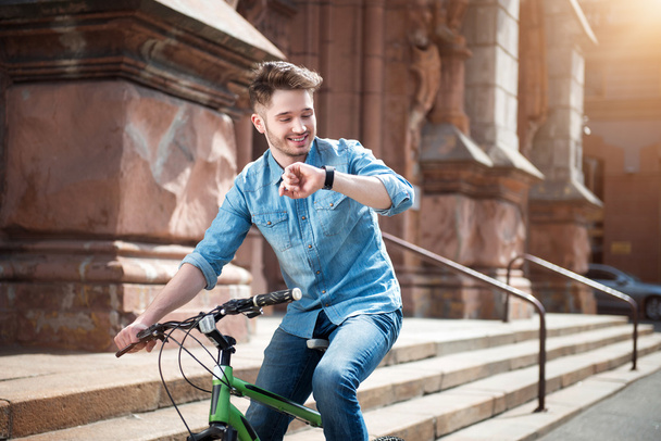 Positive guy sitting on the bicycle - Zdjęcie, obraz