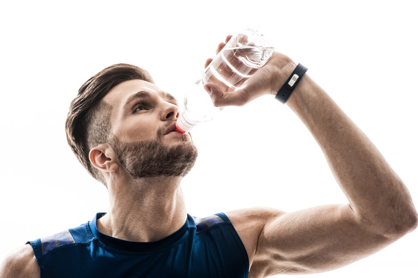 Attractive male athlete drinks fresh liquid - Foto, imagen