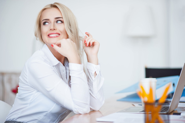 Cheerful woman sitting in the office - Photo, image