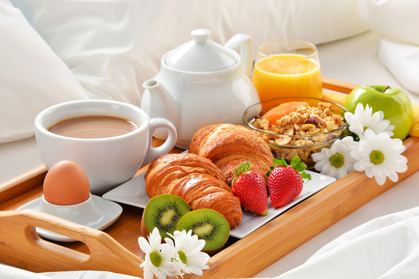Bandeja de desayuno en la cama en la habitación del hotel
 - Foto, imagen