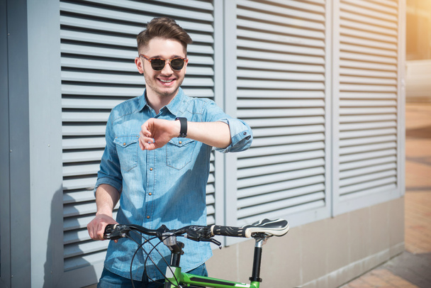 Cheerful guy holding bicycle - Zdjęcie, obraz