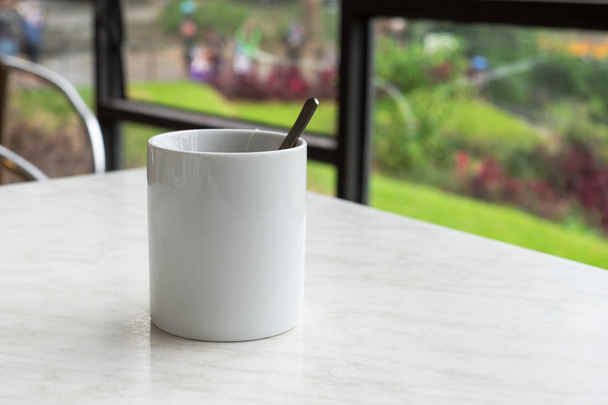 Valkoinen muki kuumaa teetä teepussi pöydällä teekaupassa
 - Valokuva, kuva