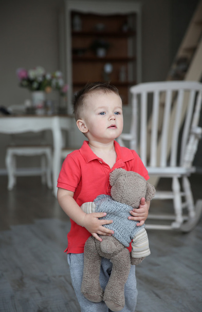 Niño jugando en la habitación con oso de juguete
 - Foto, imagen