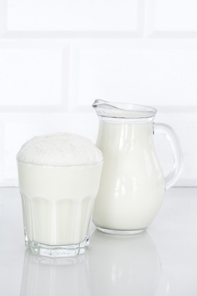 Vaso de butttermilk sobre mesa blanca
 - Foto, Imagen