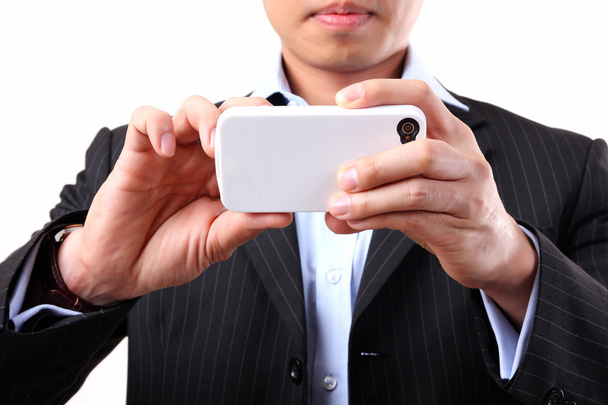 Businessman using a mobile camera on the white background - Fotó, kép