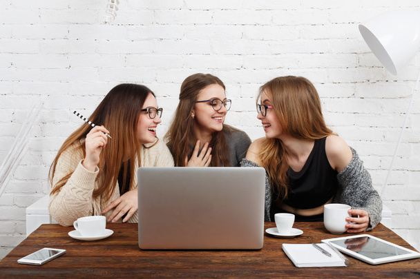 Portrait of three laughing girlfriends with laptop. - Photo, Image
