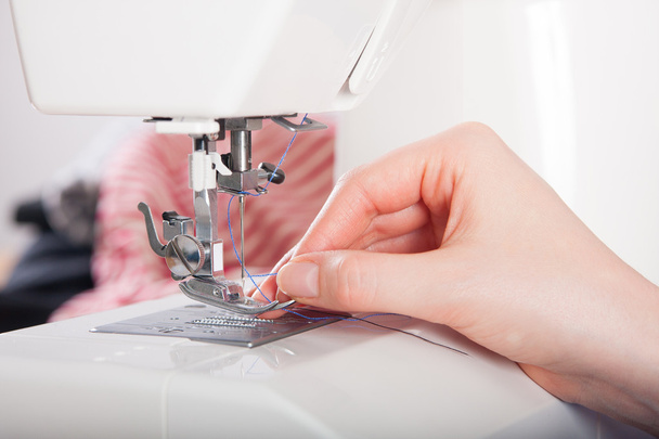 Woman threading on sewing machine - Foto, Imagen