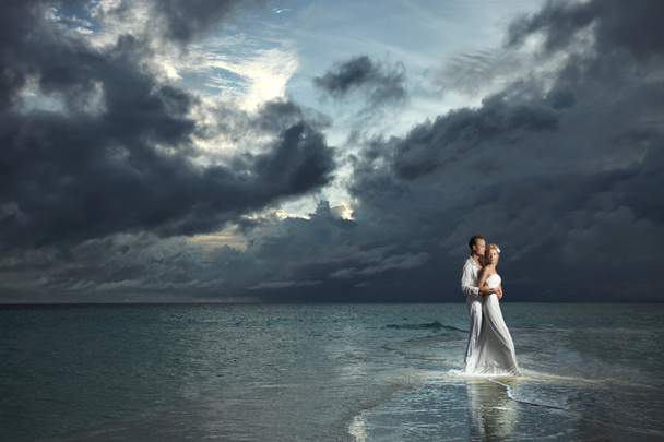 Wedding couple, bride and groom standing under threatening cloud - Fotografie, Obrázek