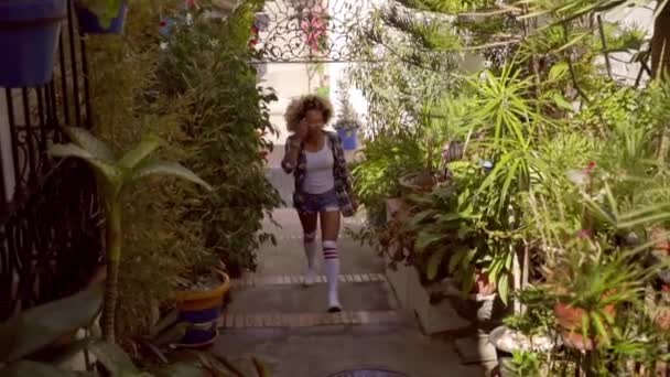woman walking on green narrow alley - Кадри, відео
