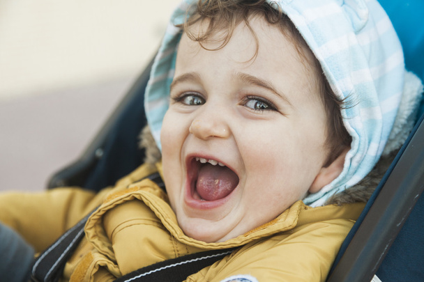 Close up portrait baby boy with big green eyes roar with laughte - 写真・画像
