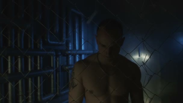 Topless człowiek z metalowego łańcuszka poza ogrodzeniem - Materiał filmowy, wideo
