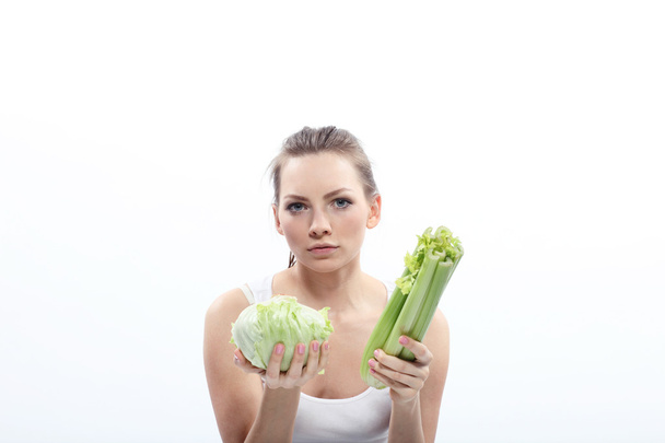 Girl holding a green cabbage and celery - Photo, Image