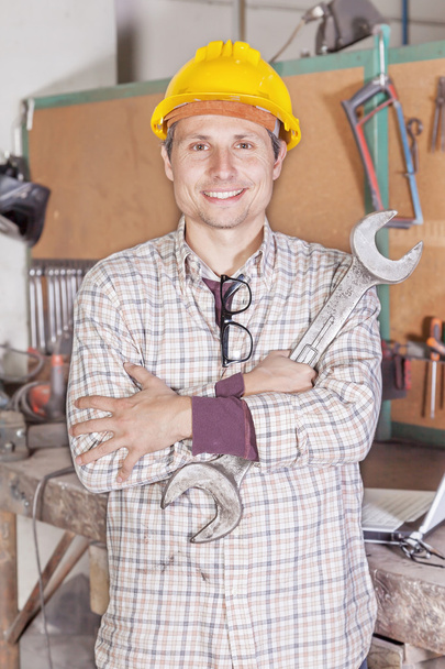 Porträt junger Metallarbeiter Arme mit Schraubenschlüssel gefaltet - Foto, Bild