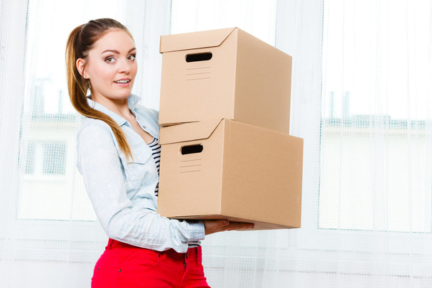 Woman moving into apartment house carrying boxes. - Fotó, kép