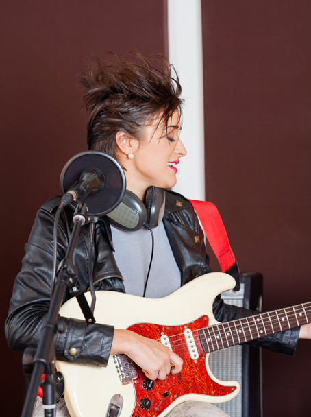 Female Guitarist Performing In Studio - Foto, immagini