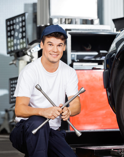 Confident Mechanic Holding Rim Wrench At Garage - Φωτογραφία, εικόνα