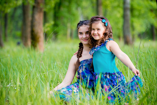 Deux sœurs allongées sur l'herbe et sourire mignon
 - Photo, image