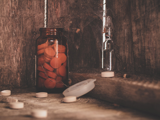 Pills in a jar on a shelf of old cobwebby. - Photo, image