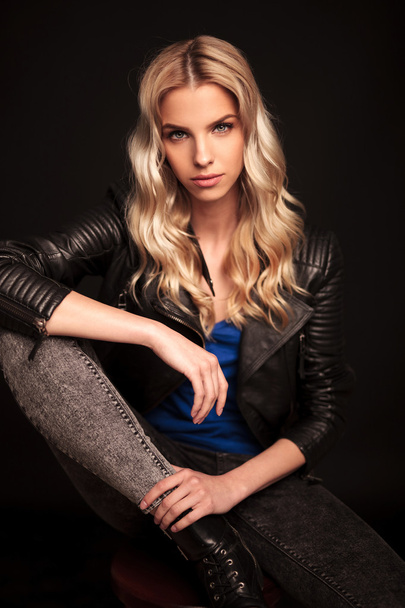  blonde biker woman in leather jacket resting hand on knee - Fotoğraf, Görsel