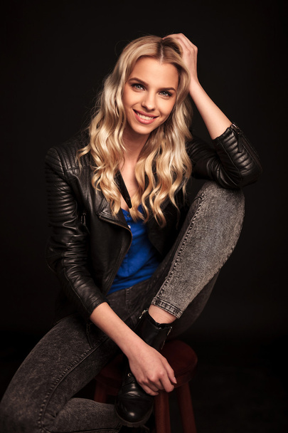  blond woman in leather jacket resting her head on hand - Foto, Imagem