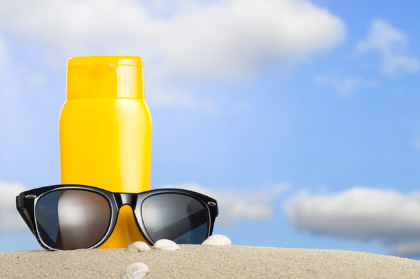 Schlauch mit Sonnenschutz und Sonnenbrille am Strand - Foto, Bild