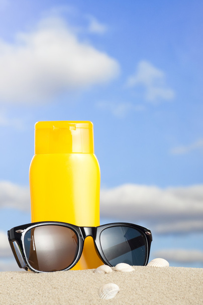 Tube avec protection solaire et lunettes de soleil sur la plage
 - Photo, image