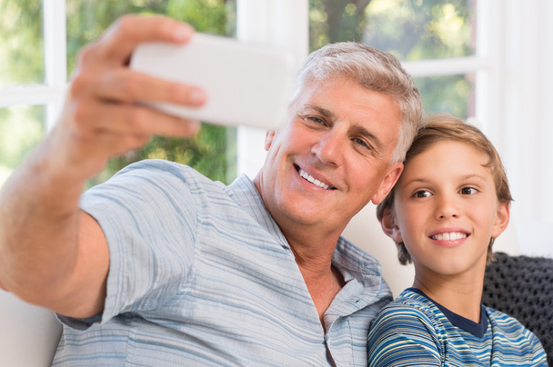 Grandfather taking selfie with grandson - Valokuva, kuva