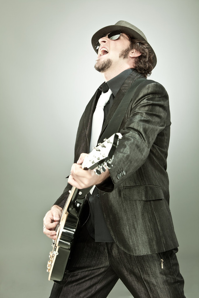 Guitarrista divertido en concierto aislado en gris
 - Foto, imagen