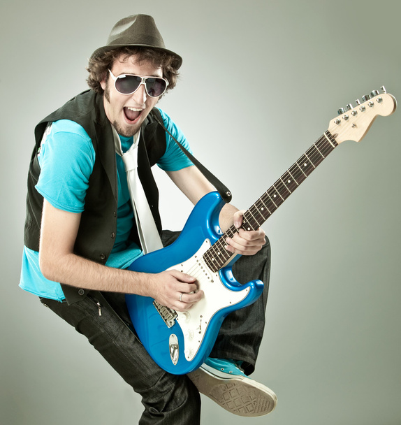 funny guitar player in concert isolated on grey - Foto, immagini