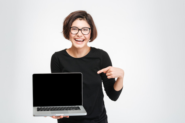 Woman pointing finger on blank laptop computer screen - Фото, зображення