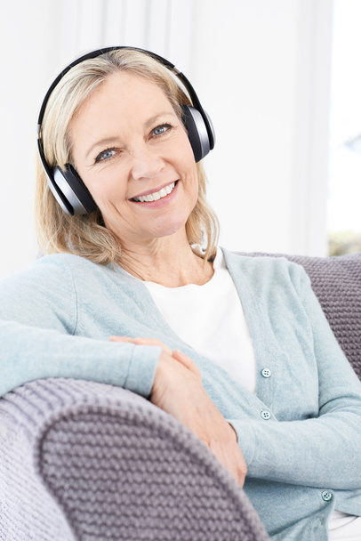 Mature Woman Listening To Music On Wireless Headphones - Foto, Bild