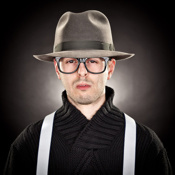 young man nerd with hat and glasses on black background - Valokuva, kuva