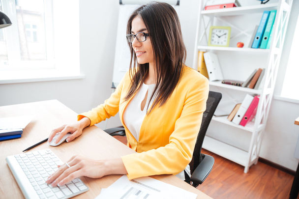 Businesswoman using keyboard and computer mouse in office - Foto, Bild