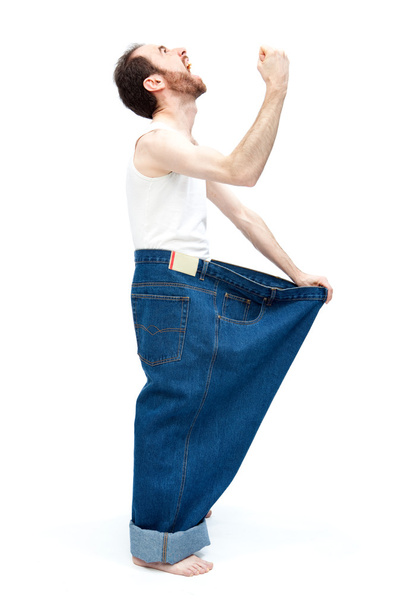 funny slim man with large pants jeans isolated on white - Foto, Bild