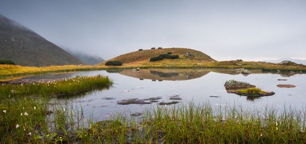 Small Tarn with Rocks in Foggy Mountains - 写真・画像