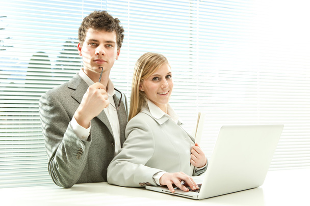 Young business couple work laptop with venetian blind window background - Φωτογραφία, εικόνα