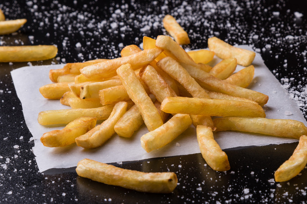 fries on a black table with sea salt - Photo, Image